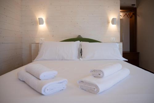 a white bed with two folded towels on it at Vicolo Effe in Terracina