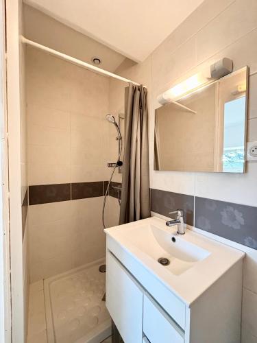 une salle de bain avec un lavabo et une douche dans l'établissement Le Cocon - Jardin - Wifi, à Vaux-sur-Mer