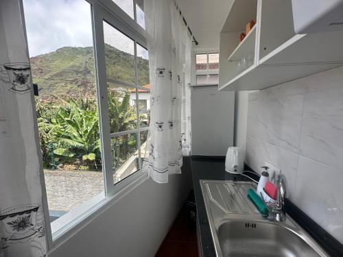 a kitchen with a sink and a window at Gori House in Madalena do Mar
