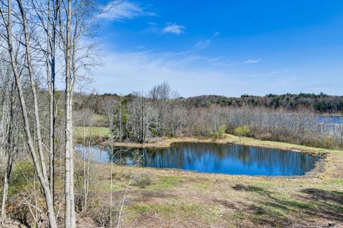 a pond in the middle of a field with trees at Golf, Fish and Ski Retreat with Game Room in Thompson in Thompson