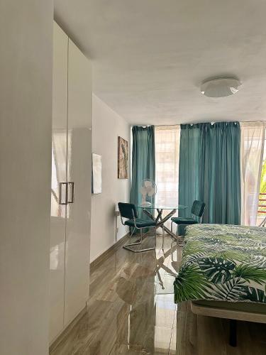 una camera da letto con un letto, un tavolo e delle sedie di Olympia 424 a Playa de las Americas
