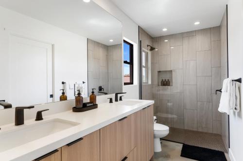 a bathroom with a sink and a toilet at Sleek 4BR Desert Home w Pool BBQ Firepit Yucca Haven by AvantStay in Yucca Valley