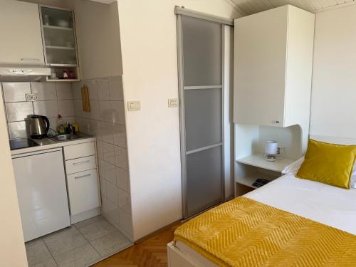 a small room with a bed and a kitchen at Apartments Olga 2 in Makarska