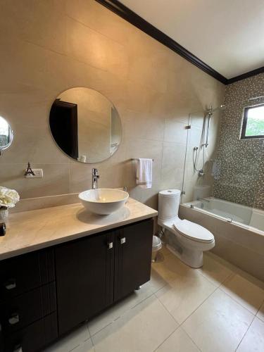 a bathroom with a sink and a toilet and a mirror at Wonderful House in Piedades