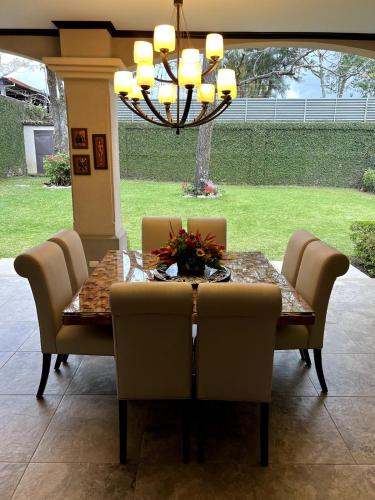 a dining room table with chairs and a chandelier at Wonderful House in Piedades