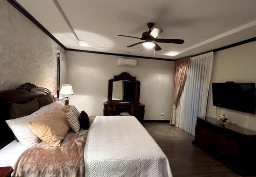a bedroom with a bed and a ceiling fan at Wonderful House in Piedades