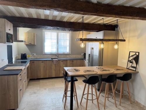 - une cuisine avec une table et quelques tabourets de bar dans l'établissement O Bastidon du Ventoux, à Bédoin