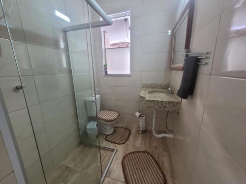 a bathroom with a shower and a sink at Apto na Rua Principal - Centro in Serra Negra