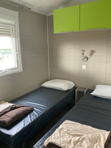 Katil atau katil-katil dalam bilik di Menthalo 4 étoiles La Presqu île du Barcarés Mobil Home 6 pers premium climatisé