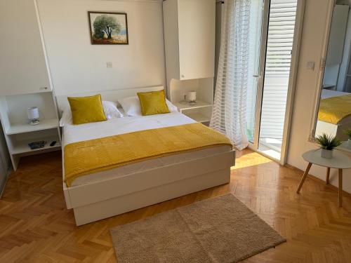 a bedroom with a bed with yellow pillows at Apartments Olga 2 in Makarska