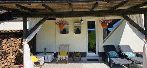 a patio with two chairs and a wooden pergola at Bezdroża Mazurskie in Mrągowo
