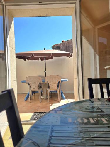 une table et des chaises avec un parasol sur une terrasse dans l'établissement Maison Guy-Nadette, à Saint-Georges-de-Didonne