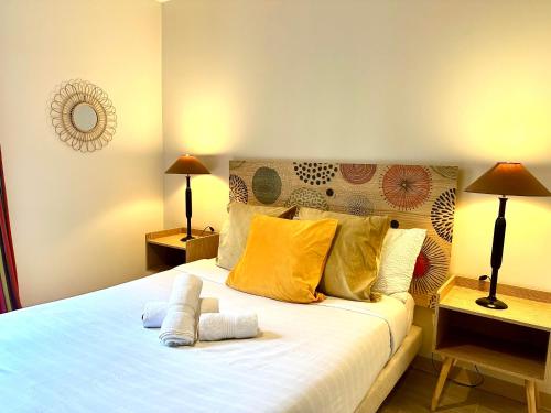 une chambre avec un grand lit avec des oreillers jaunes dans l'établissement LE GABRIEL - Charmant 2 pièces aux portes de Paris, à Malakoff
