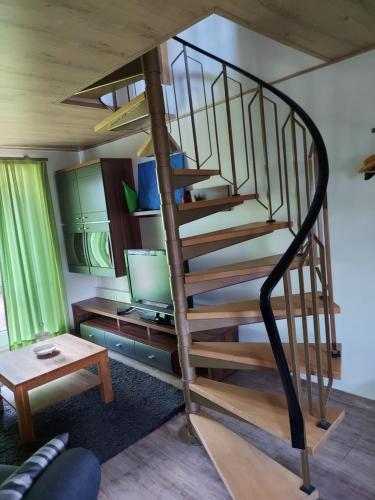 a spiral staircase in a living room with a tv at Haus Norderteich in Horn-Bad Meinberg