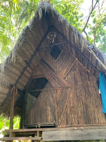 a hut with a thatched roof on top of it at Amazon jungle cabin - satorinatural in Puerto Nariño