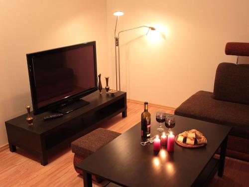 a living room with a television and a table with a bottle of wine at Ubytovanie Eva in Oščadnica