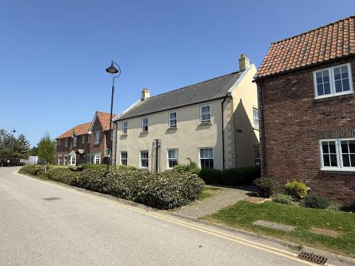 a white house on the side of a street at Apartment Ivy - Part of the The Bay Filey Holiday Village with pool, gym and direct beach access, pub, restaurant, tennis and meadows walks in Filey