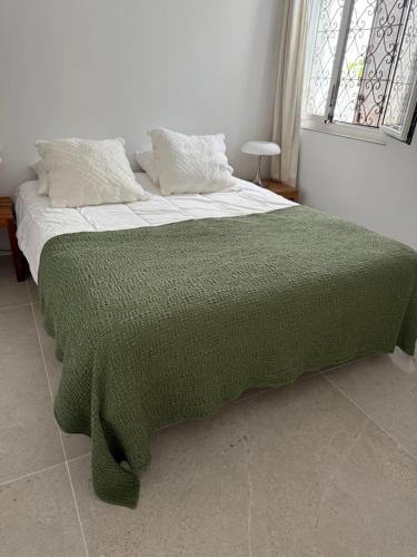 a green blanket on a bed in a bedroom at Villa la Grande Bastide piscine et tennis collectif in Cassis