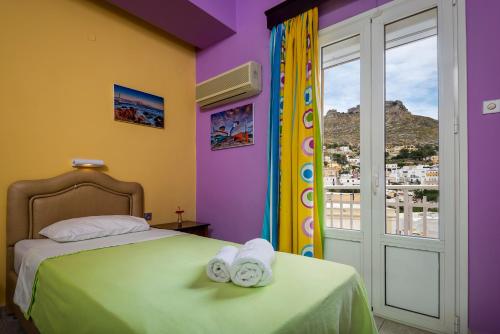 une chambre avec un lit avec des serviettes dessus dans l'établissement Elefteria Hotel, à Agia Marina