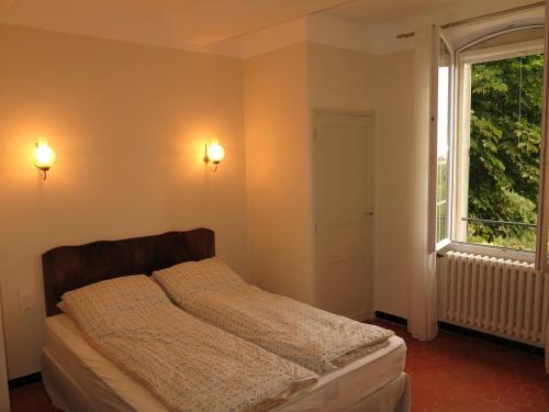 une chambre avec un lit et une grande fenêtre dans l'établissement Large house in Cotignac Bastide Saint-Martin, à Cotignac