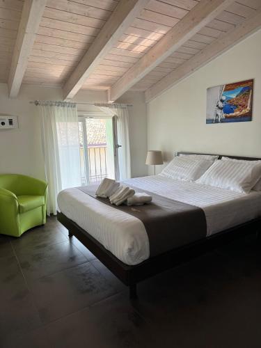 a bedroom with a large bed and a green chair at Residence Del Lago in Desenzano del Garda