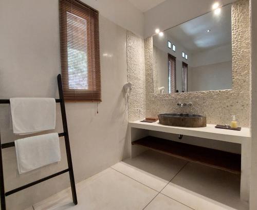 un baño con lavabo y espejo en Villa Sari and Rubi, en Senggigi 