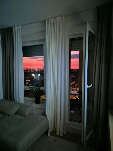 a living room with a couch and a window at Knezev Park Apartment in Novi Sad