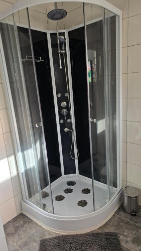 une douche avec une cabine en verre dans une salle de bain dans l'établissement Maison de ville, à Pontonx-sur-lʼAdour