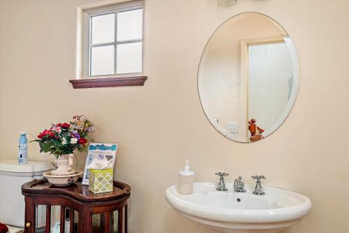 ein Badezimmer mit Waschbecken und Spiegel an der Wand in der Unterkunft A Dolphin Dreams in Cambria