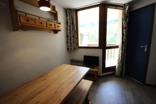 Cette chambre dispose d'une table en bois et d'une fenêtre. dans l'établissement Résidence Praz De L'ours 1 - Studio 4 personnes à Vallandry en centre station et proche des pistes MAE-1960, à Peisey-Nancroix