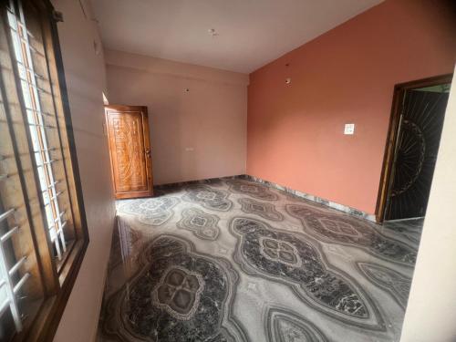 an empty room with a carpeted floor and a door at Tej Home Stays and Guest House in Miriālgūda