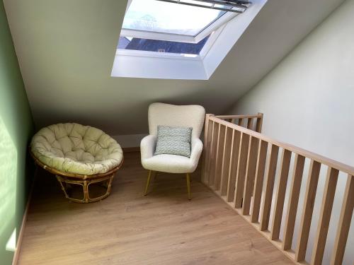 a stair room with a chair and a skylight at Gite Le Petit Nid - 3 chambres in Couvin