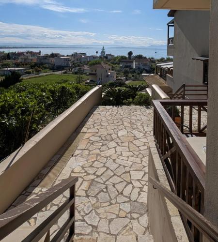 a stone walkway leading to a balcony of a house at Althea Apartments in Katakolon