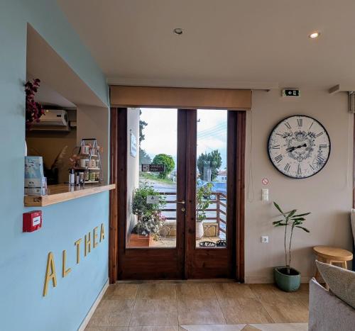 a large clock on the wall above a door at Althea Apartments in Katakolon