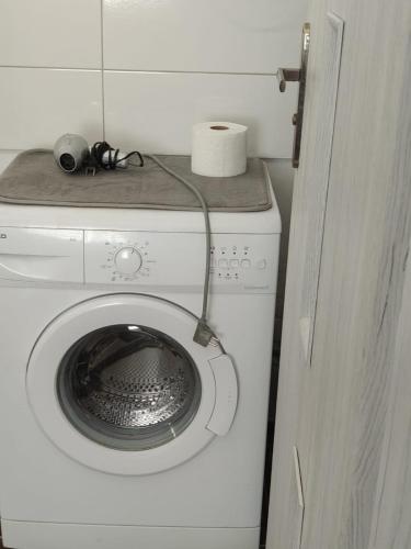 a white washing machine with a cord attached to it at Apartament W SERCU PARKU in Ełk