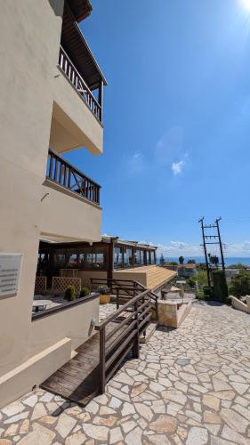 a large building with a staircase and a balcony at Althea Apartments in Katakolon