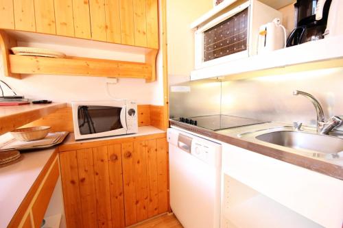 une petite cuisine avec un évier et un micro-ondes dans l'établissement Résidence Arc En Ciel - Appartement 2 pièces 5 personnes à Vallandry en centre station et à côté des pistes MAE-2063, à Peisey-Nancroix