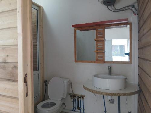 a bathroom with a toilet and a sink and a mirror at résidence IDIMAH in Sada