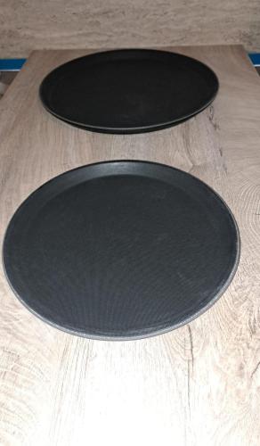 two black plates sitting on top of a wooden table at 4 Rooms Piata Sfatului in Braşov