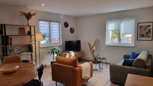 a living room with a couch and a table at L'atelier - logement neuf sur la route des vins d'Alsace in Voegtlinshoffen