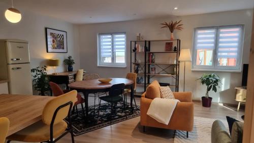 a kitchen and living room with a table and chairs at L'atelier - logement neuf sur la route des vins d'Alsace in Voegtlinshoffen