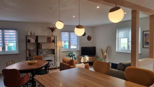 a living room with a table and a couch at L'atelier - logement neuf sur la route des vins d'Alsace in Voegtlinshoffen