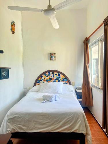 a bedroom with a large bed with a white blanket at Hotel Mary Carmen in Cozumel