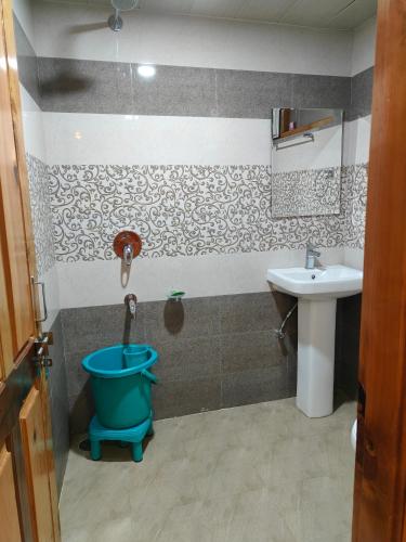 a bathroom with a bucket and a sink at Flugafen B&B- A Peaceful home in Apple Orchards in Manāli