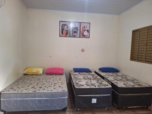 3 camas sentadas en una habitación con una pared en Recanto famila lago das brisas, en Corumbazul
