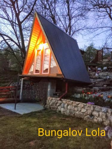 a small house with a solar roof and a window at Kuca za odmor Lola in Ivanjica