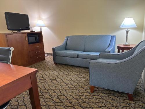 a living room with a couch and a tv at Baymont by Wyndham Mishawaka South Bend Area in Mishawaka