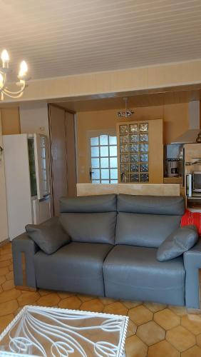 un salon avec un canapé bleu et une cuisine dans l'établissement Mihechris, à Collioure