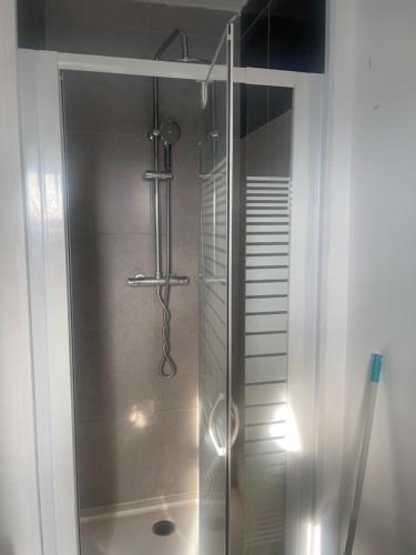 une douche avec une porte vitrée dans une salle de bain dans l'établissement CMJJ Hope 2etage, à Calais