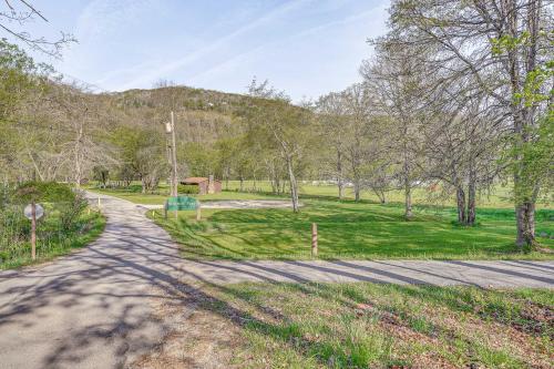 a road leading to a park with trees and grass at Hike and Fish Marlinton Cabin with Fire Pit and Views! in Marlinton